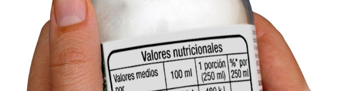 Manos con un yoghurt etiquetado con la información nutricional