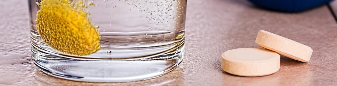 Comprimido efervescente diluyéndose en un vaso de agua