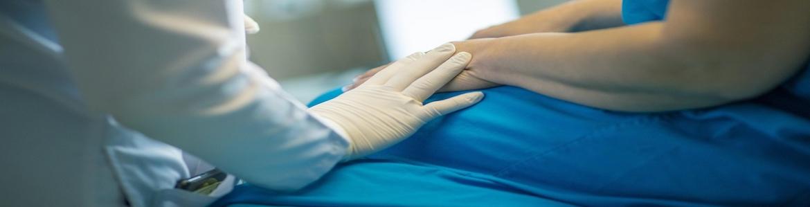 Profesional sanitario apoyando su mano en un paciente