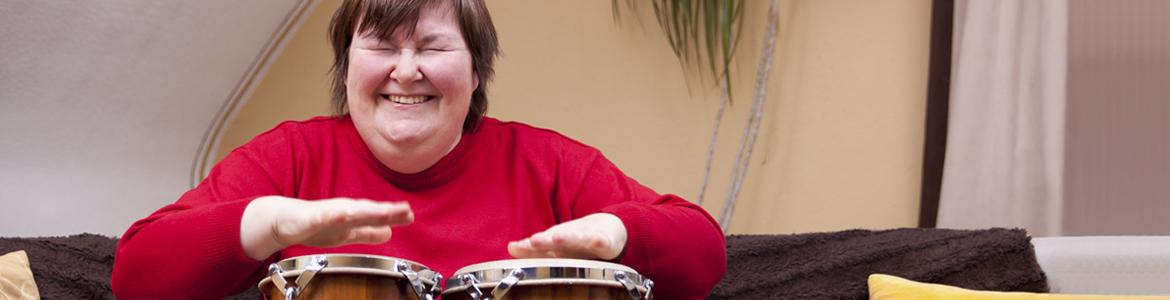 Imagen ilustrativa de una mujer con discapacidad tocando un instrumento de percusión