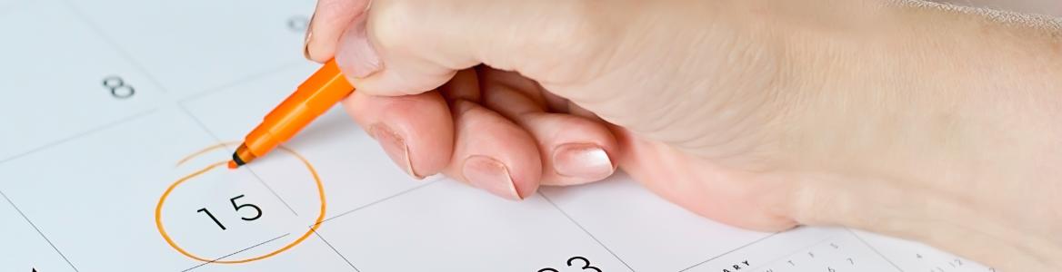 Mano de mujer señalando día de un calendario