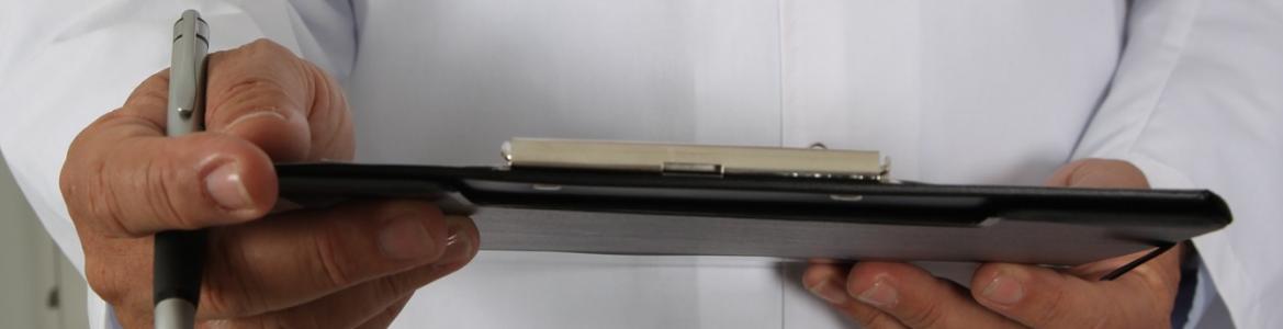 Médico escribiendo en una carpeta