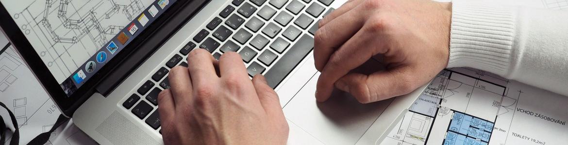 manos de hombre trabajando con ordenador y documentos