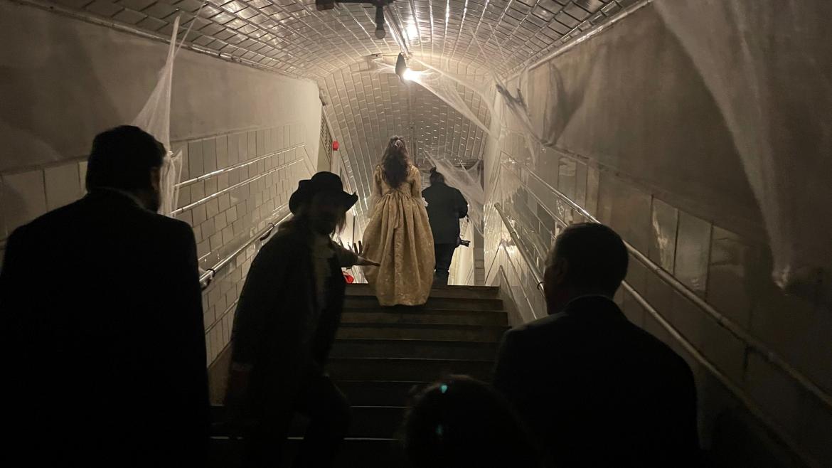 Los personajes disfrazados subiendo una escalera del Metro