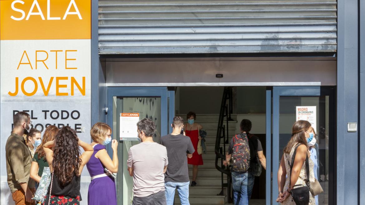 Grupo de personas en la puerta de una sala de exposiciones