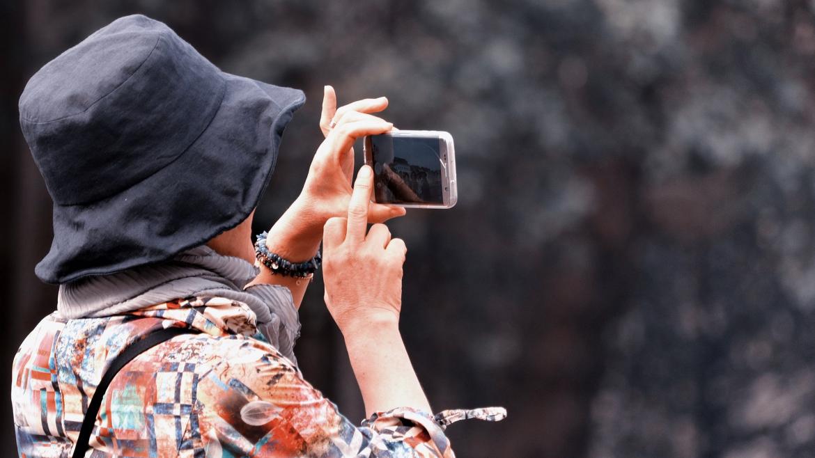 Mujer haciendo foto con teléfono móvil