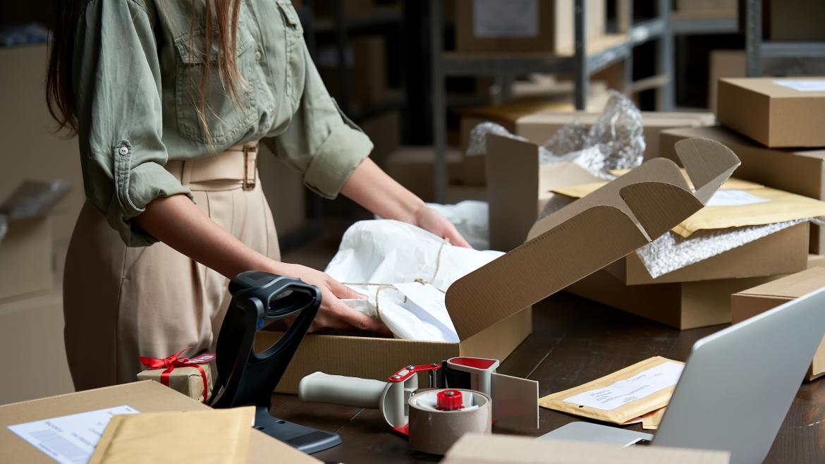 Una mujer guarda una ropa en una caja