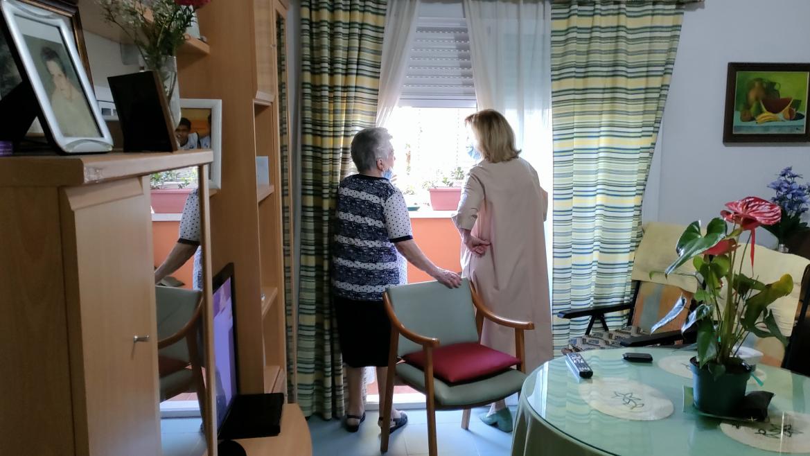La consejera Concepción Dancausa junto a una señora asomadas en una ventana