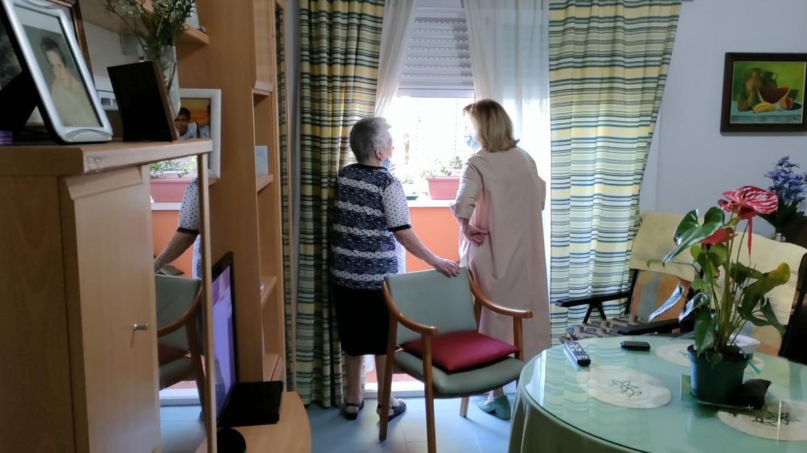 La consejera Concepción Dancausa junto a una señora asomadas en una ventana