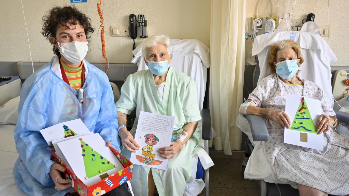 Dos pacientes y una trabajadora social con las cartas enviadas por los niños