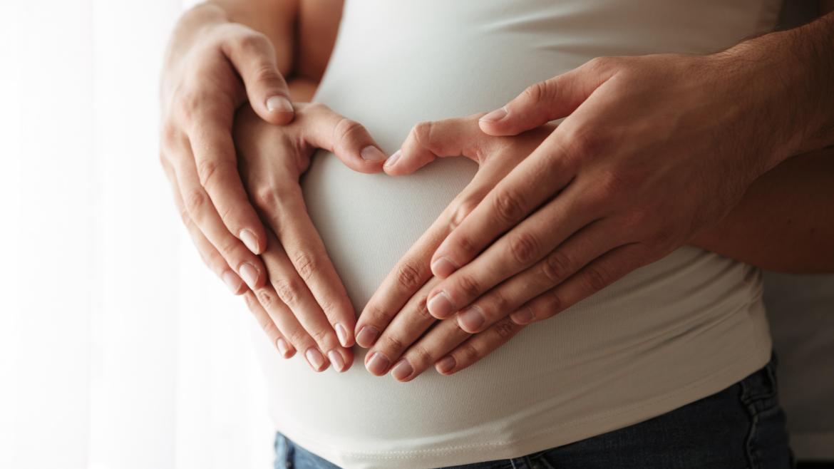 Manos de los padres sobre la tripa de embarazo