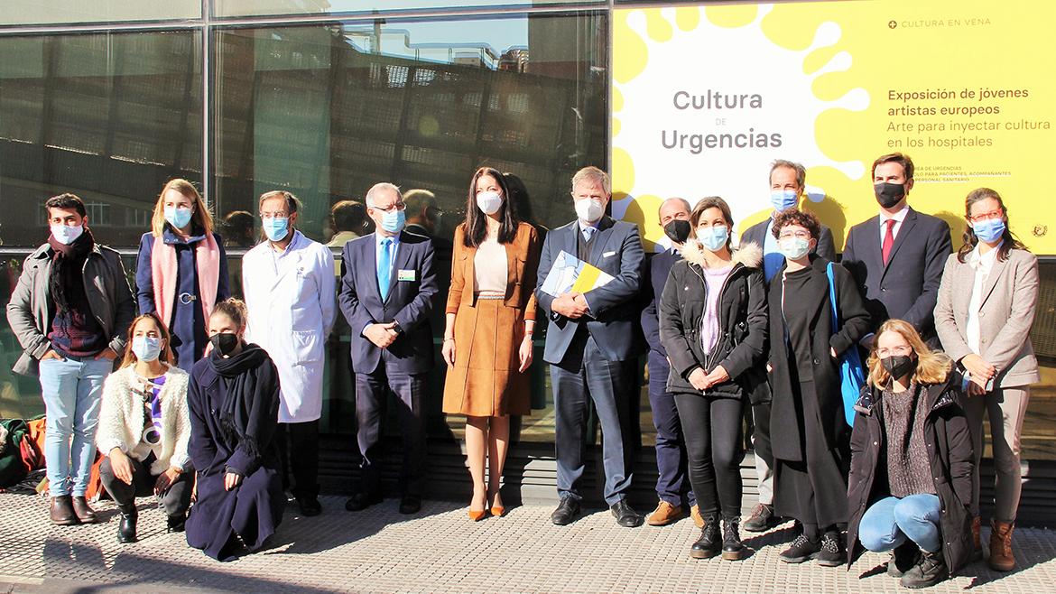 Autoridades y profesionales sanitarios junto a jóvenes artistas ante el cartel de la exposición