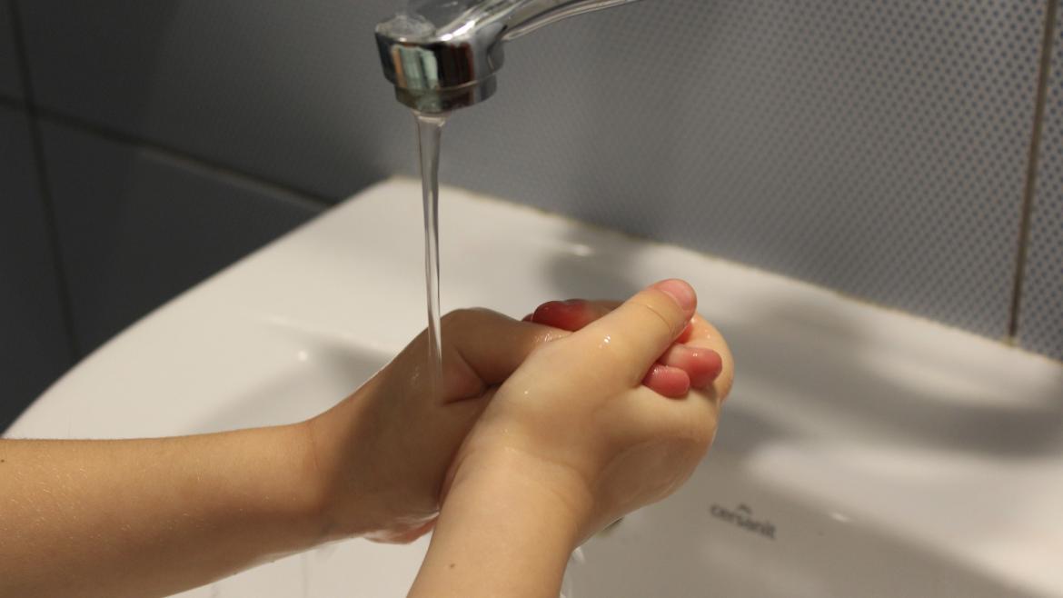 manos de niño lavandoselas en un lavabo
