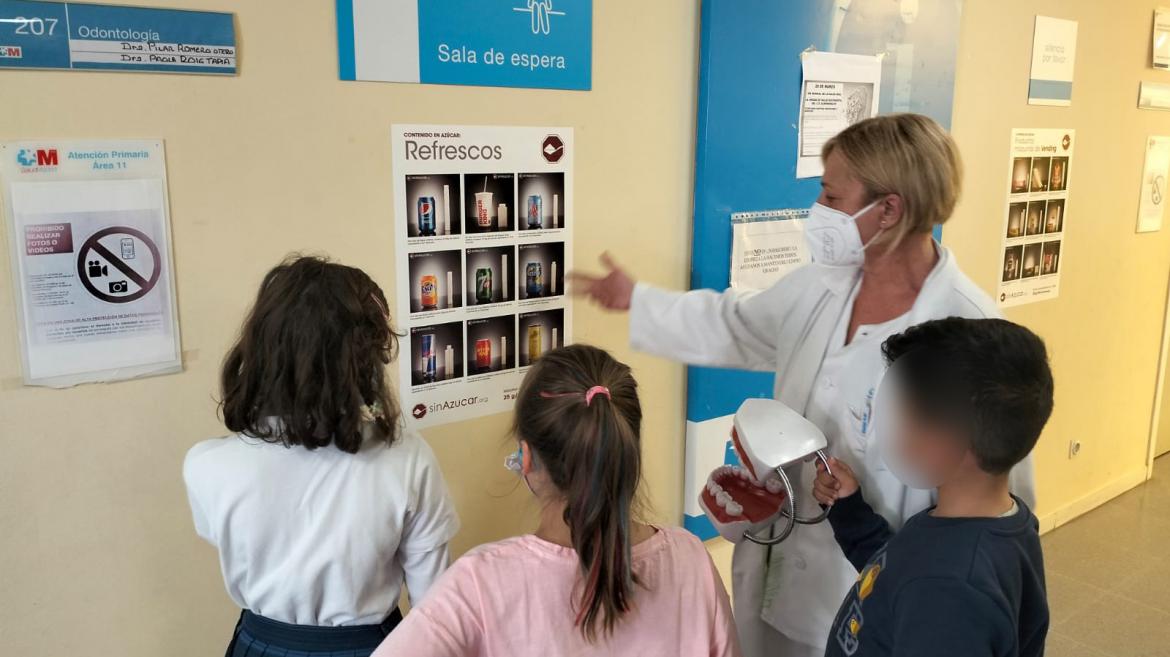 Profesional sanitario dando explicaciones a niños