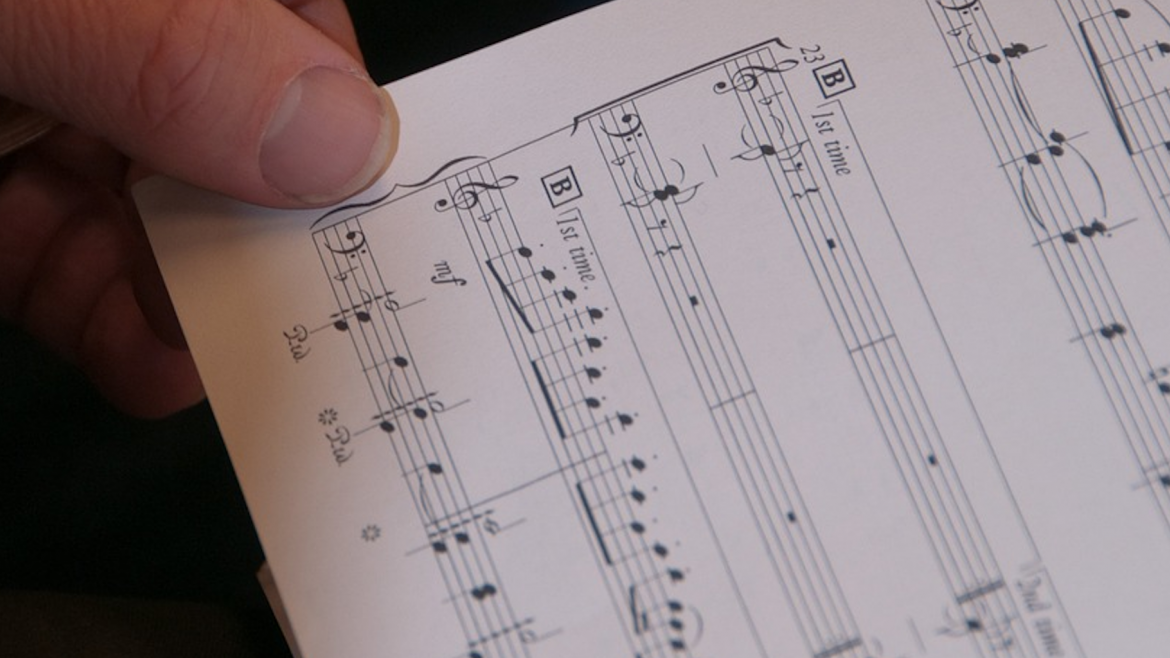Imagen de una partitura y una mano
