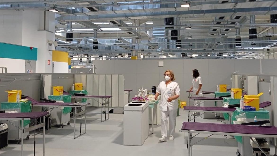 espacio abierto con seis camillas vacías y dos enfermeras