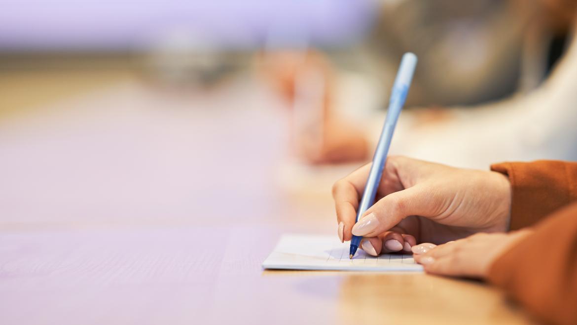 Las manos de una estudiante universitaria escribiendo
