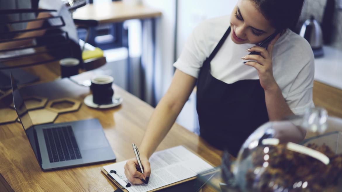 Una mujer atiende una llamada en un bar que es una franquicia