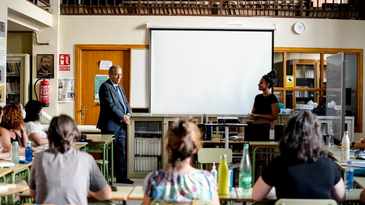 El consejero Enrique Ossorio mientras observa una clase con alumnos y su profesora