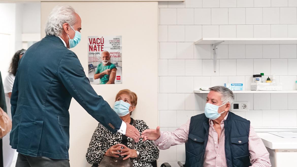 El consejero saludando a dos personas que se vacunan
