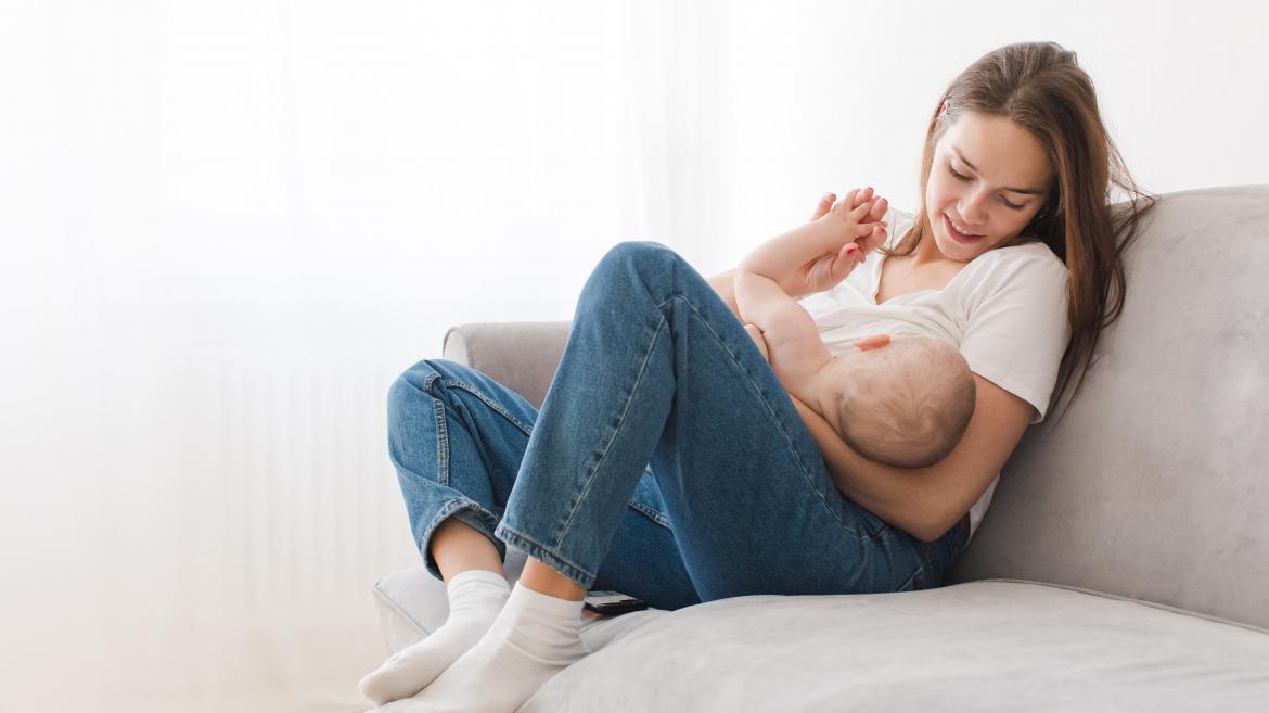 Madre sentada sillon con bebe