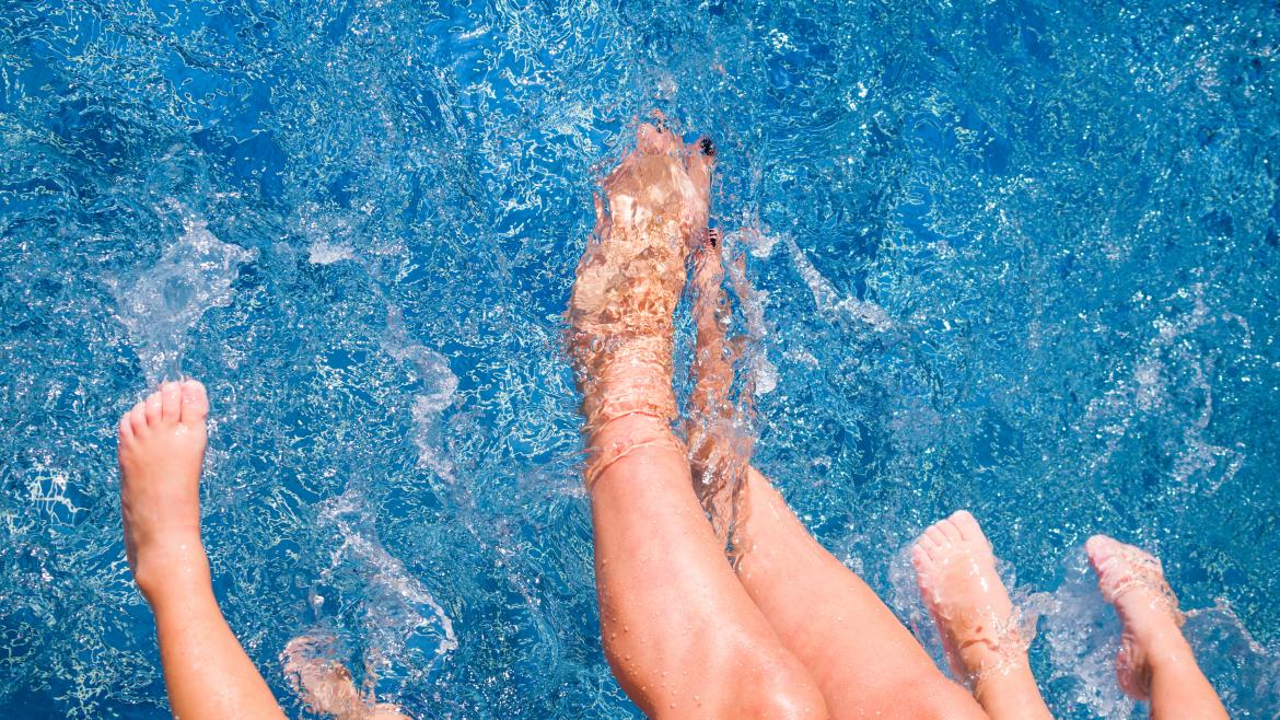 Unos pies remojandose en una piscina