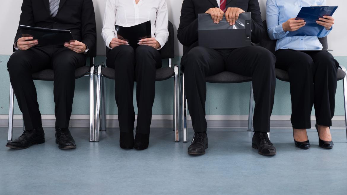 Cuatro personas sentadas esperando en entrevista de trabajo