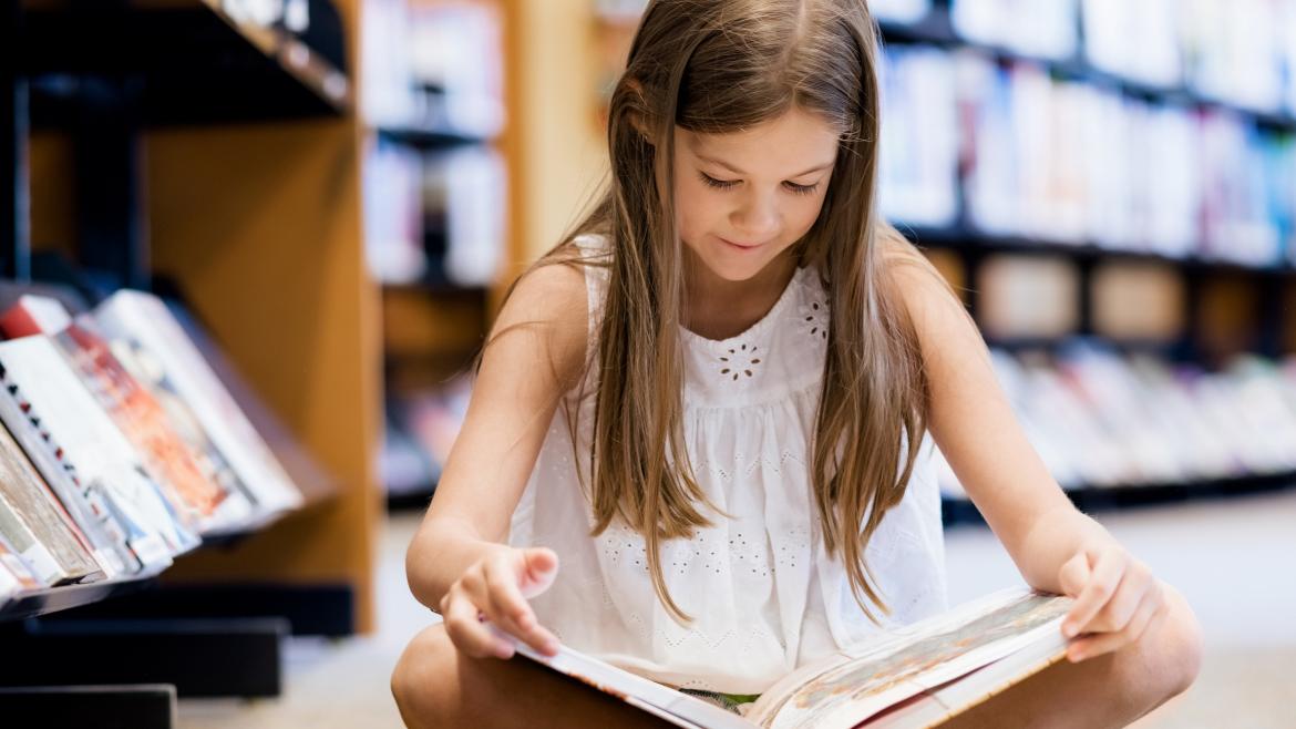 niña leyendo en una biblioteca