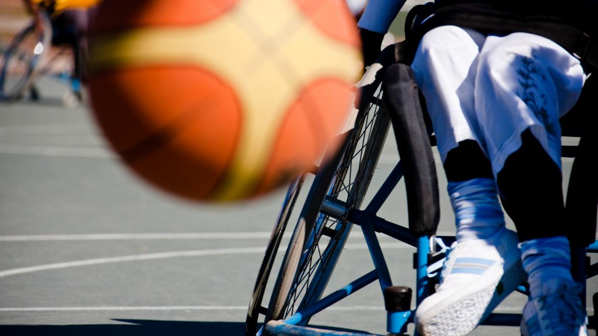 Un balón de baloncesto bota delante de un jugador de baloncesto en silla de ruedas