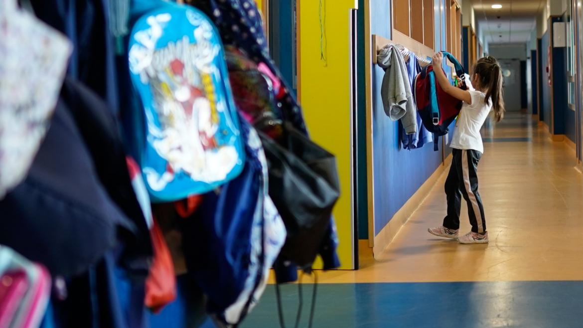 alumno Una alumna dejando su mochila en un perchero