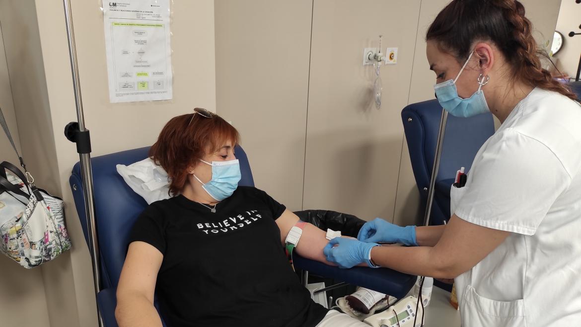 Una persona dona sangre junto a una sanitaria