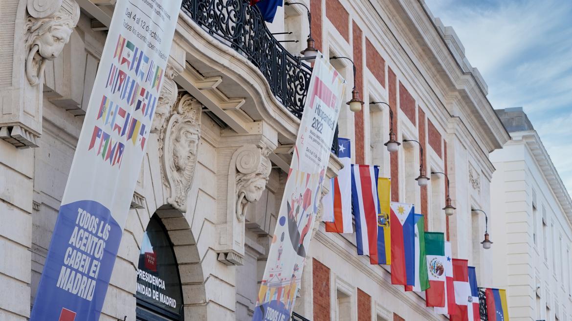 La fachada principal de la Real Casa de Correos con las banderas de los 22 países hispanohablantes