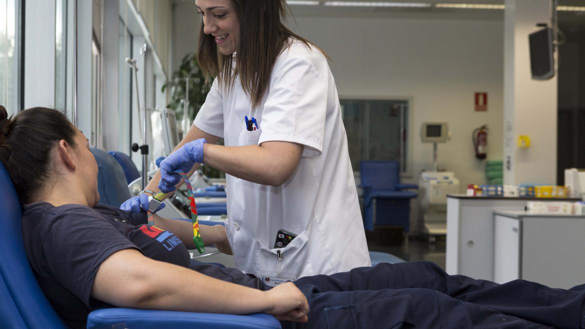Una mujer dona sangre mientras es atendida por una enfermera