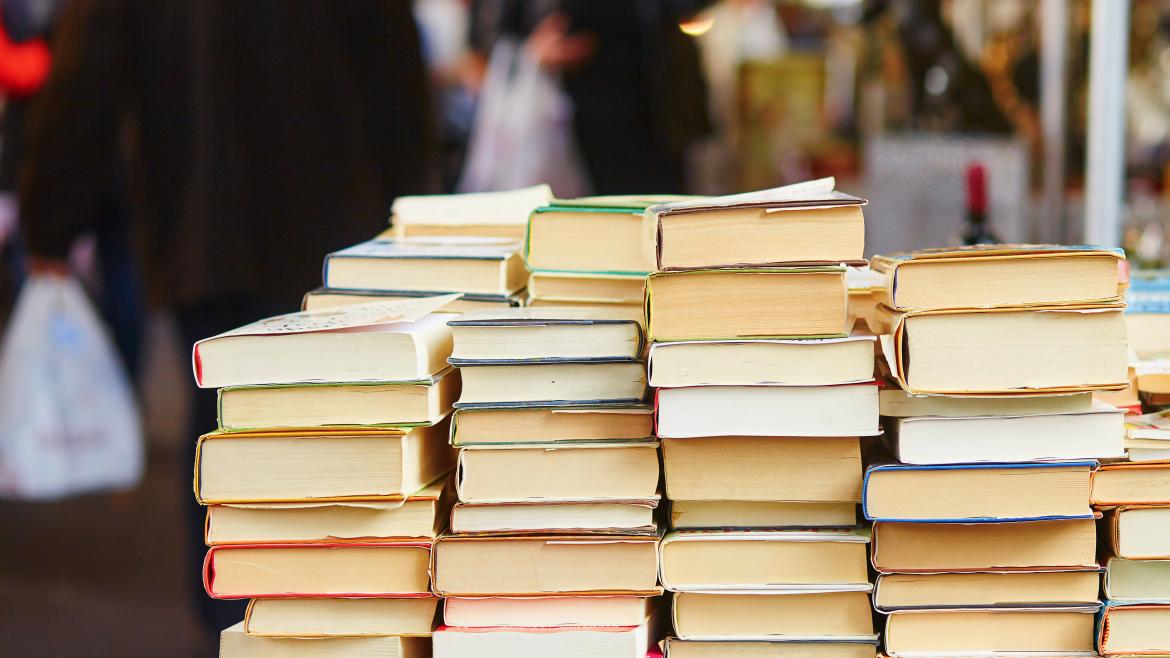 Libros apilados encima de una mesa en la calle