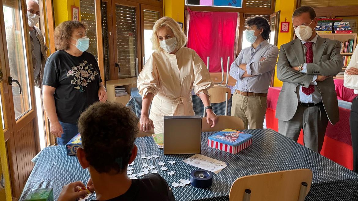 La consejera hablando con un chico que está de espaldas haciendo un puzzle en una mesa