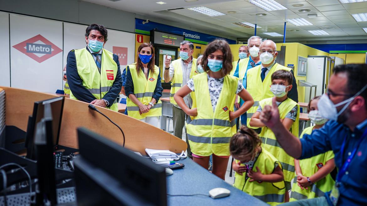 El consejero junto a un grupo de niños y abuelos escuchando las explicaciones de un trabajador de metro