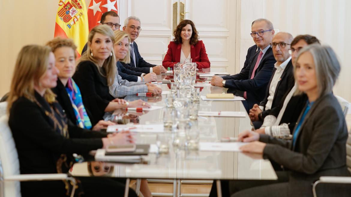 La presidenta en la mesa de la reunión junto al resto de participantes