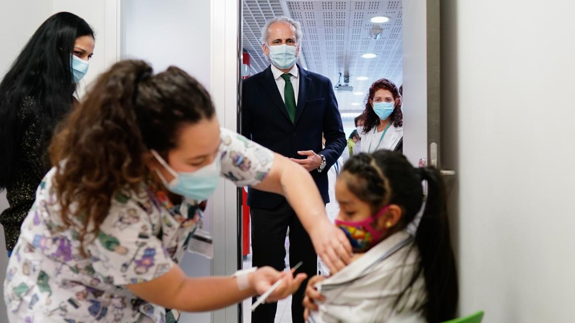 El consejero mirando como vacunan a una niña