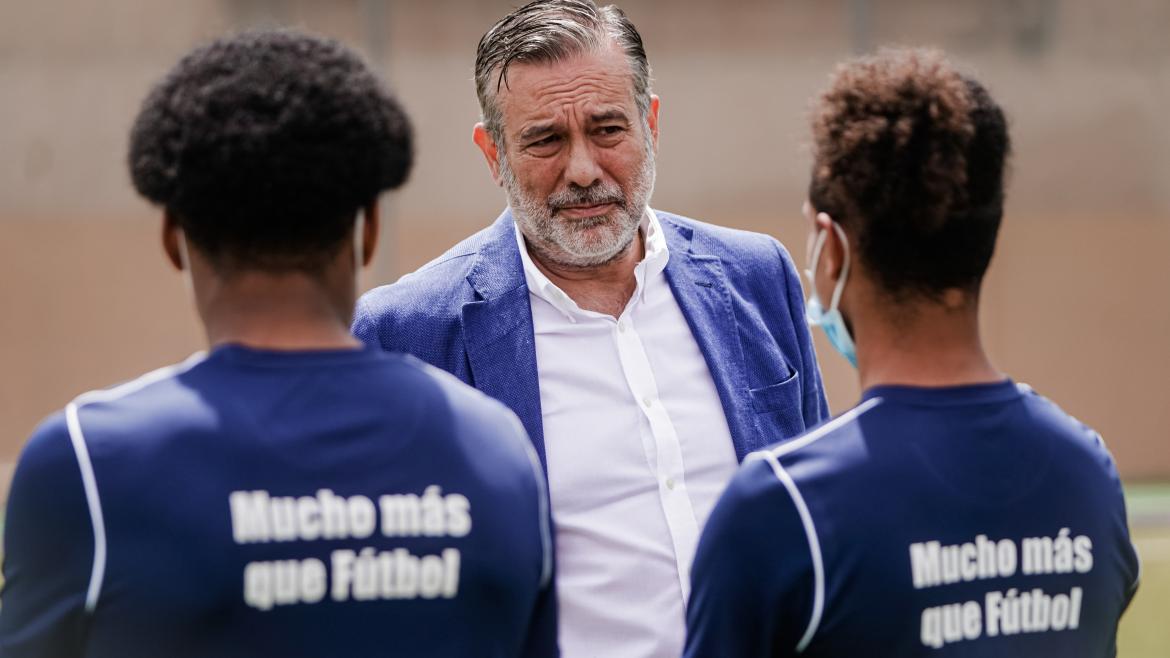 Enrique López conversa con dos jóvenes
