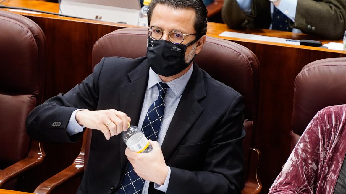 El consejero sentado en lugar en el pleno de la Asamblea de Madrid