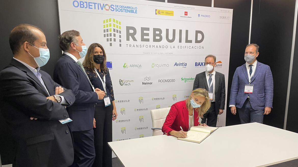 La consejera firmando el libro de visitas del evento