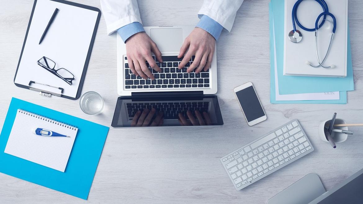 Médico escribiendo en ordenador