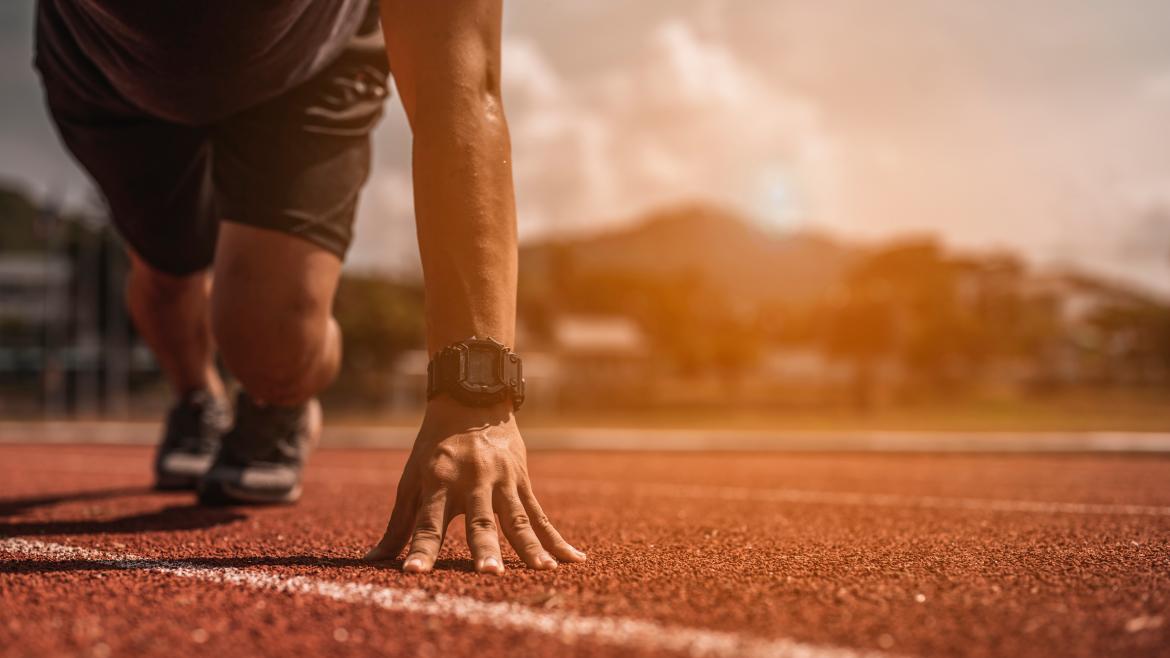 Un competidor de atletismo preparado en la pista para iniciar la carrera