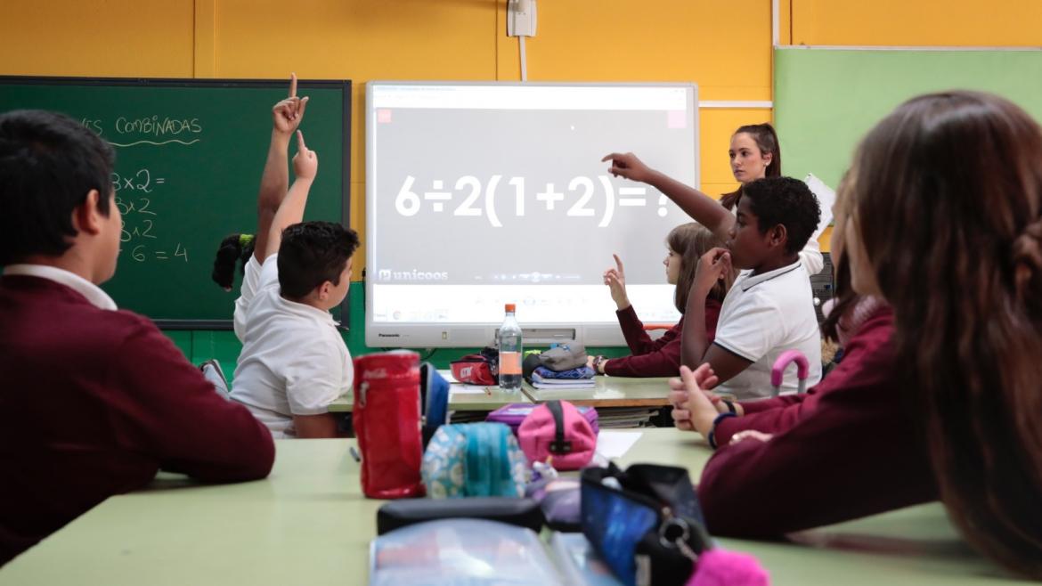 Unos niños observan a una profesora dar clase
