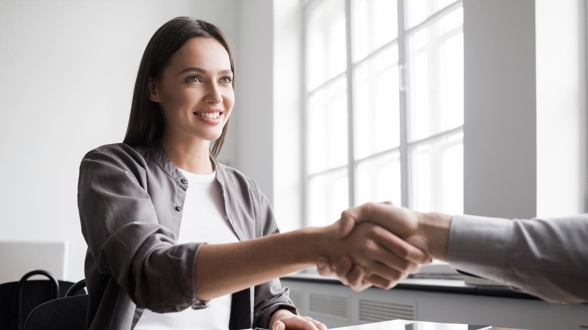 Una chica le da la mano a su nuevo trabajador