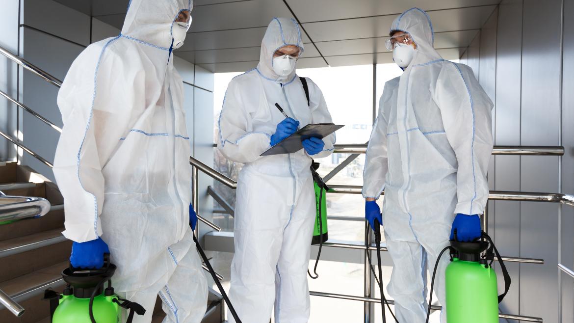 Hombres con traje de protección desinfección coronavirus