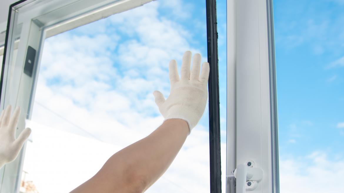 Persona conlocando cristal en una ventana
