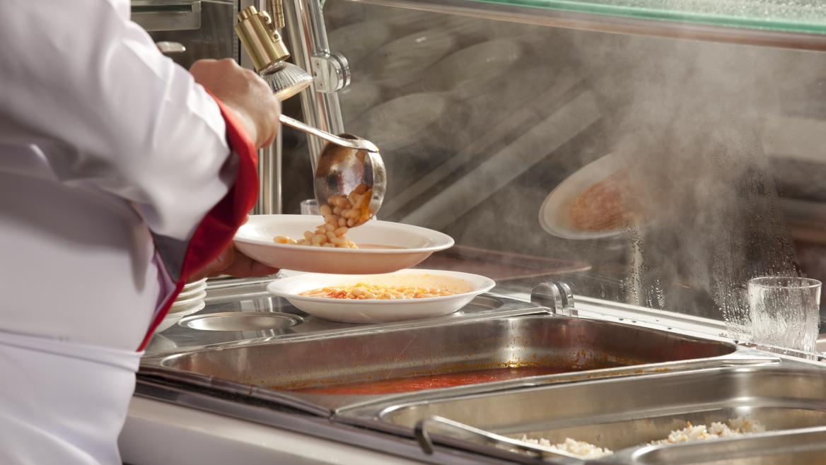 Una cocinera sirve en un comedor