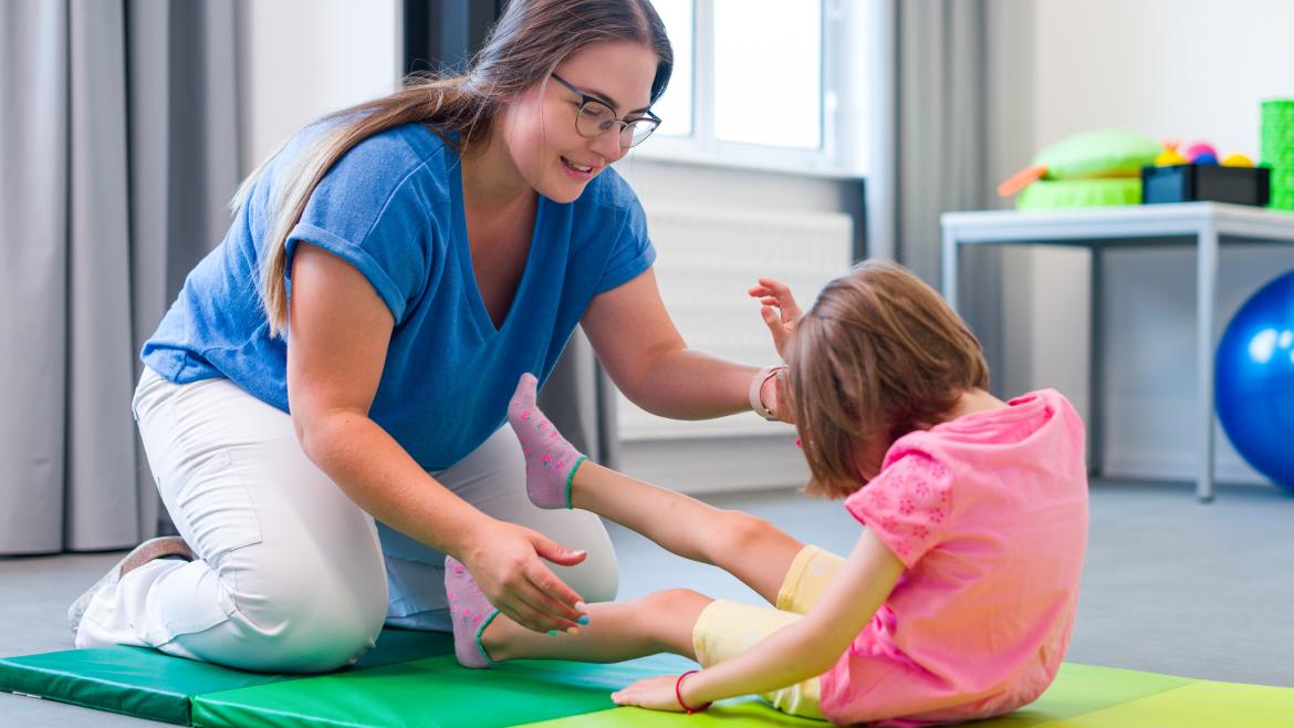 fisio con niños Una profesional de la fisioterapia con una alumna en un colegio