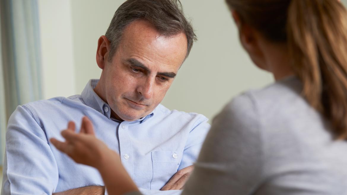 Psiquiatra en consulta atendiendo a un hombre